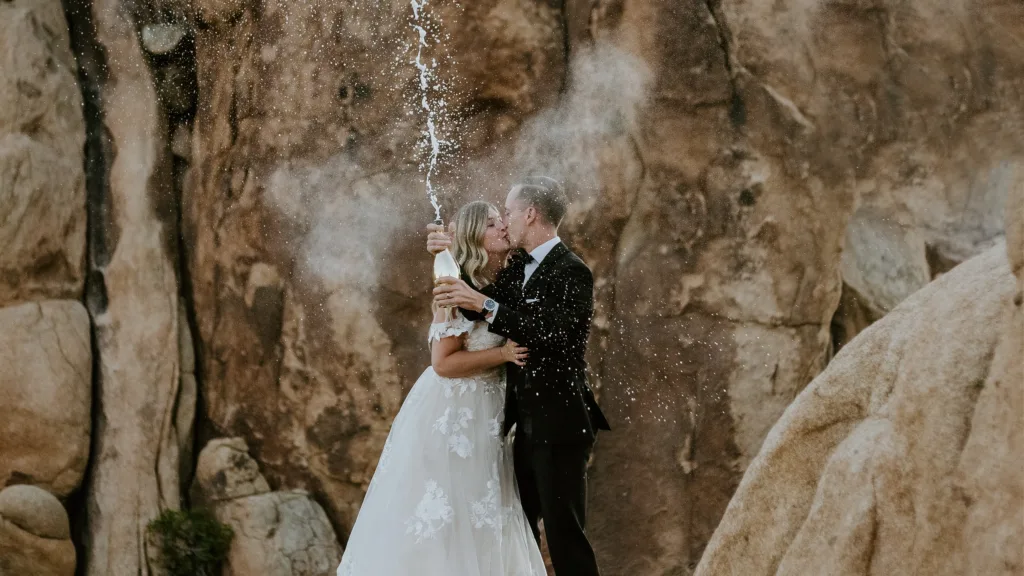 Groom and bride celebrating their elopement with champagne in Joshua Tree