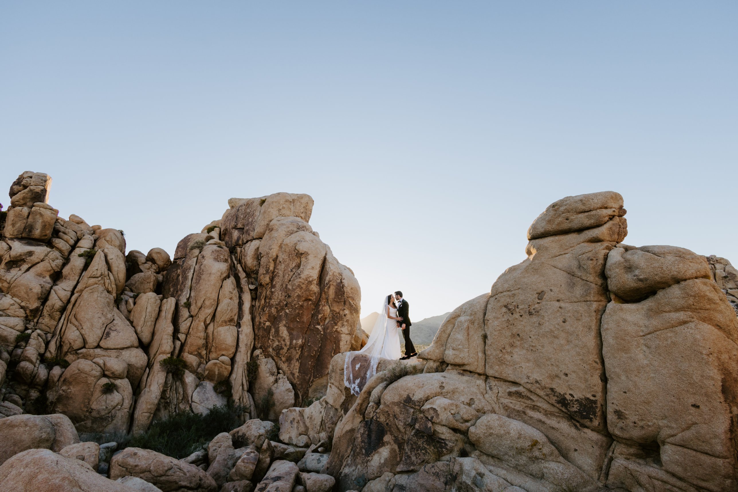 Joshua Tree elopement: couple kissing among the boulders at golden hour