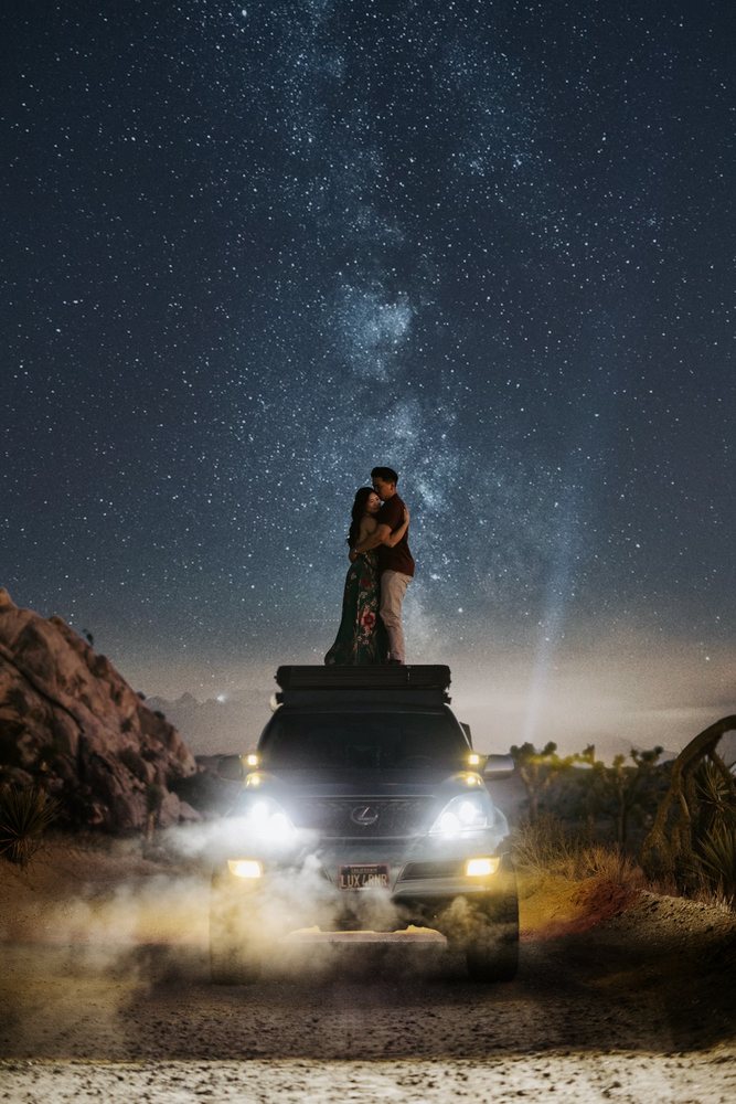 Couple kissing on a jeep under the Milky Way in Joshua Tree