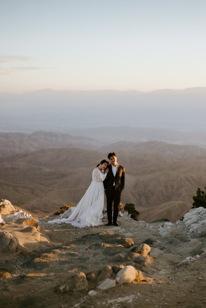 Bride leaning on her groom above the valley