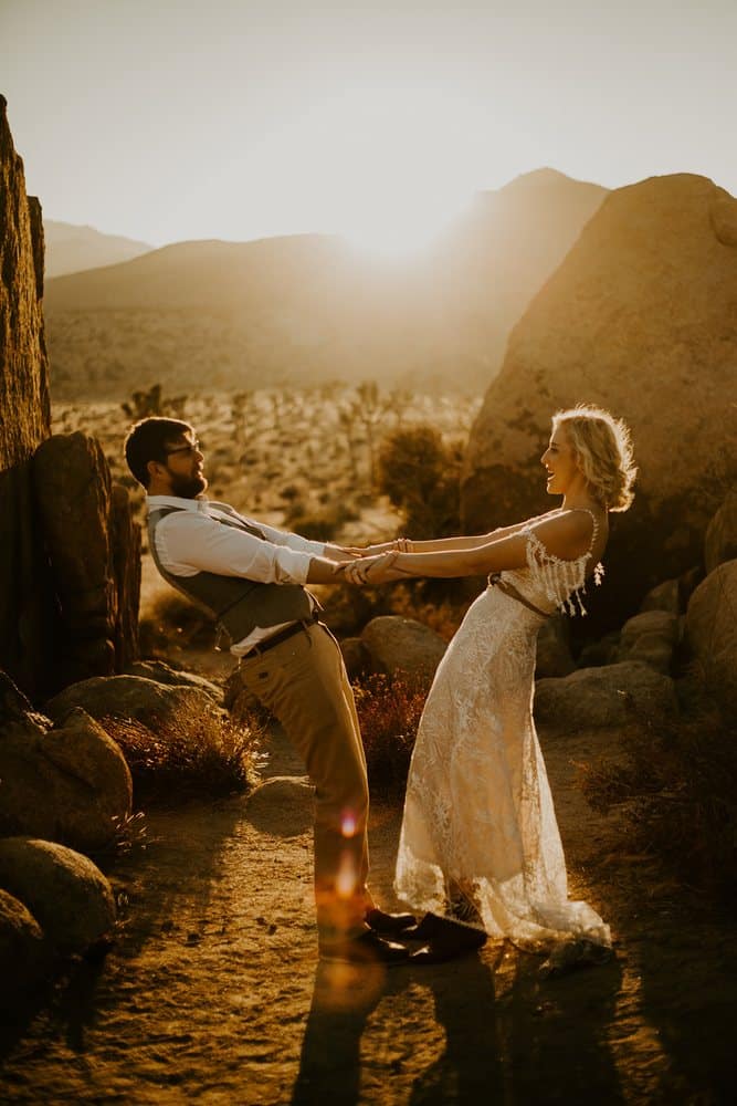 Couple holding hands among the boulders at golden hour