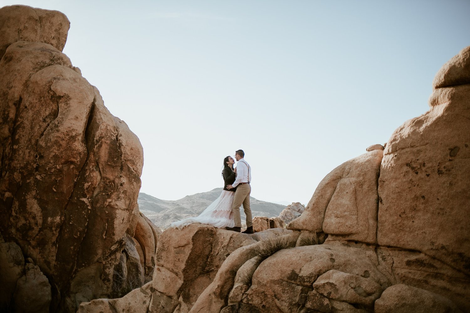 Couple on the boulders in a leather jacket