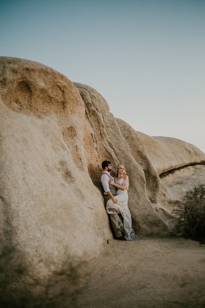 Couple small against huge granite boulders