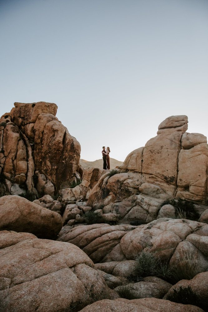 Couple standing between giant boulders