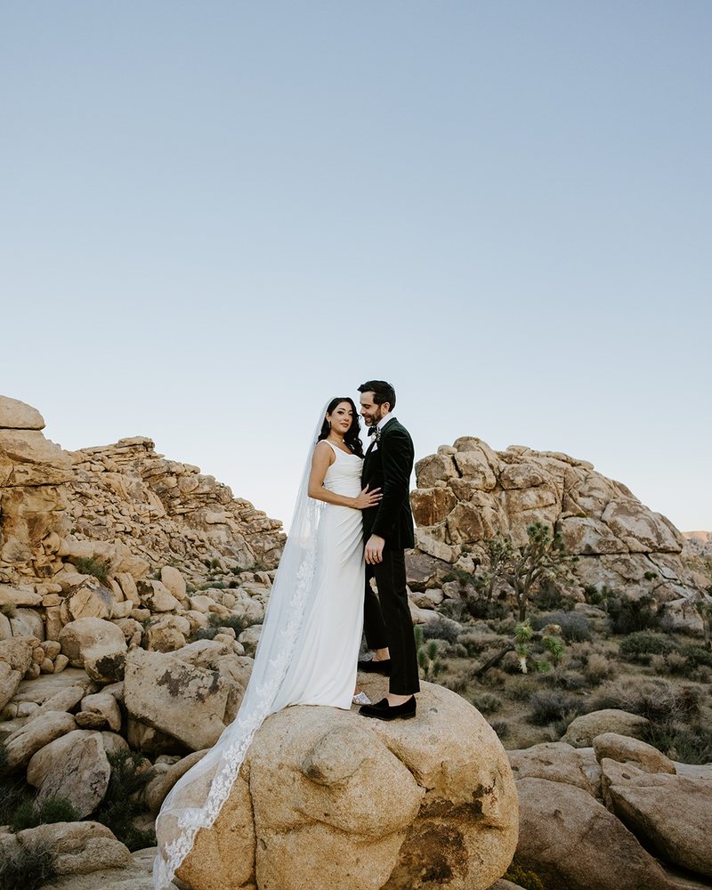 Couple standing on a boulder at golden hour