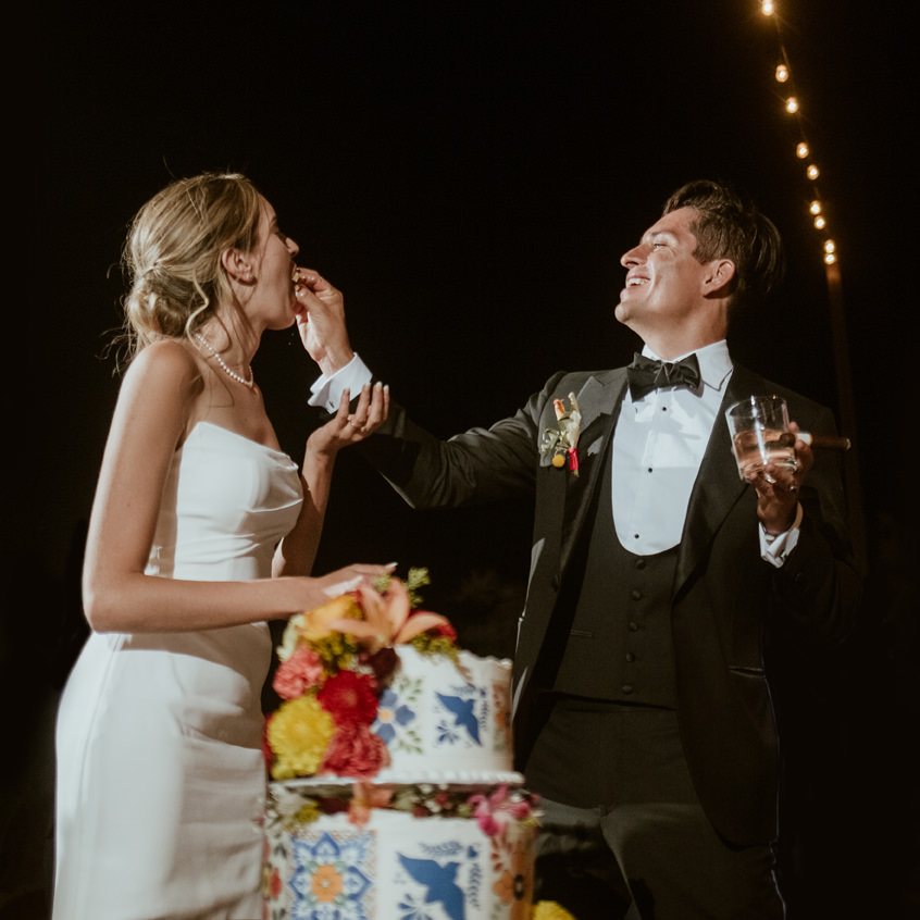 Cutting the cake under string lights