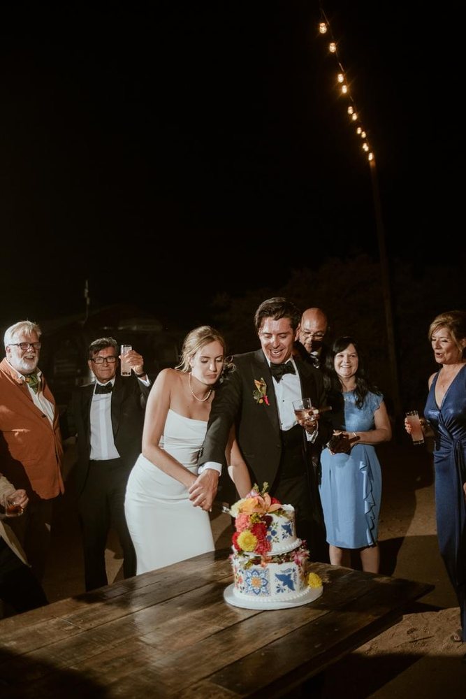 Cutting the cake with family under string lights