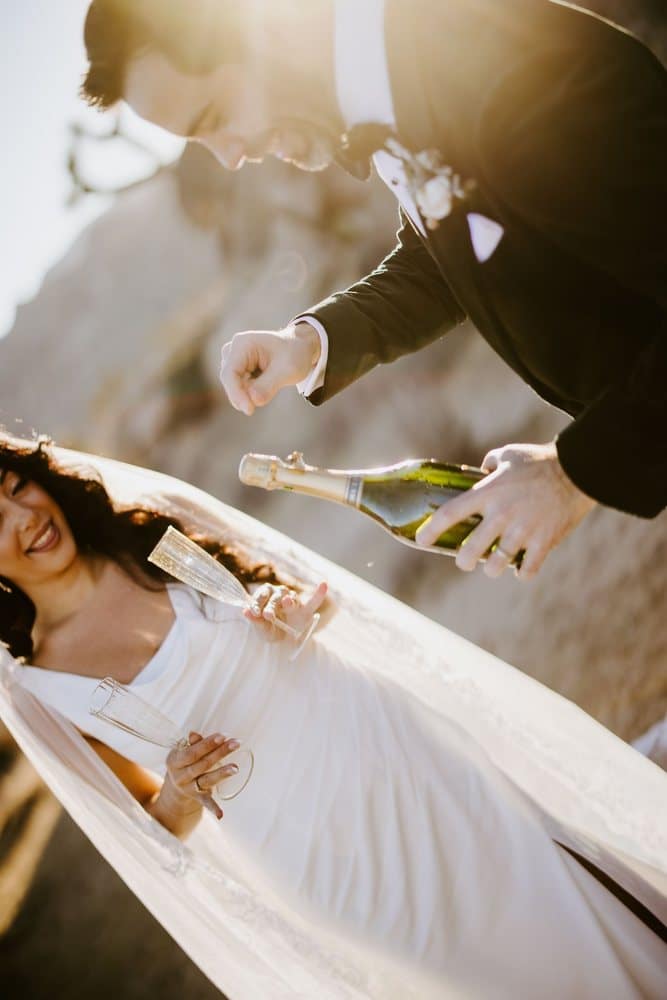 Groom pouring champagne for his bride