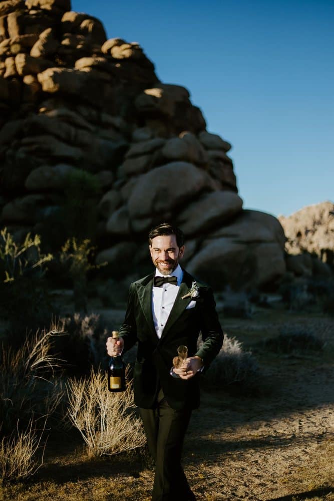Groom smiling with champagne and glasses