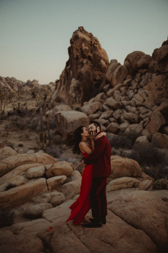 Kiss in a red dress among the boulders