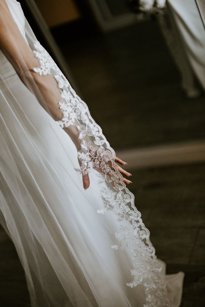Lace veil over the bride’s hand