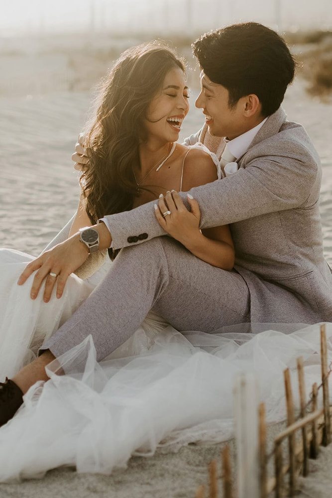 Laughing couple sitting together in the desert sand
