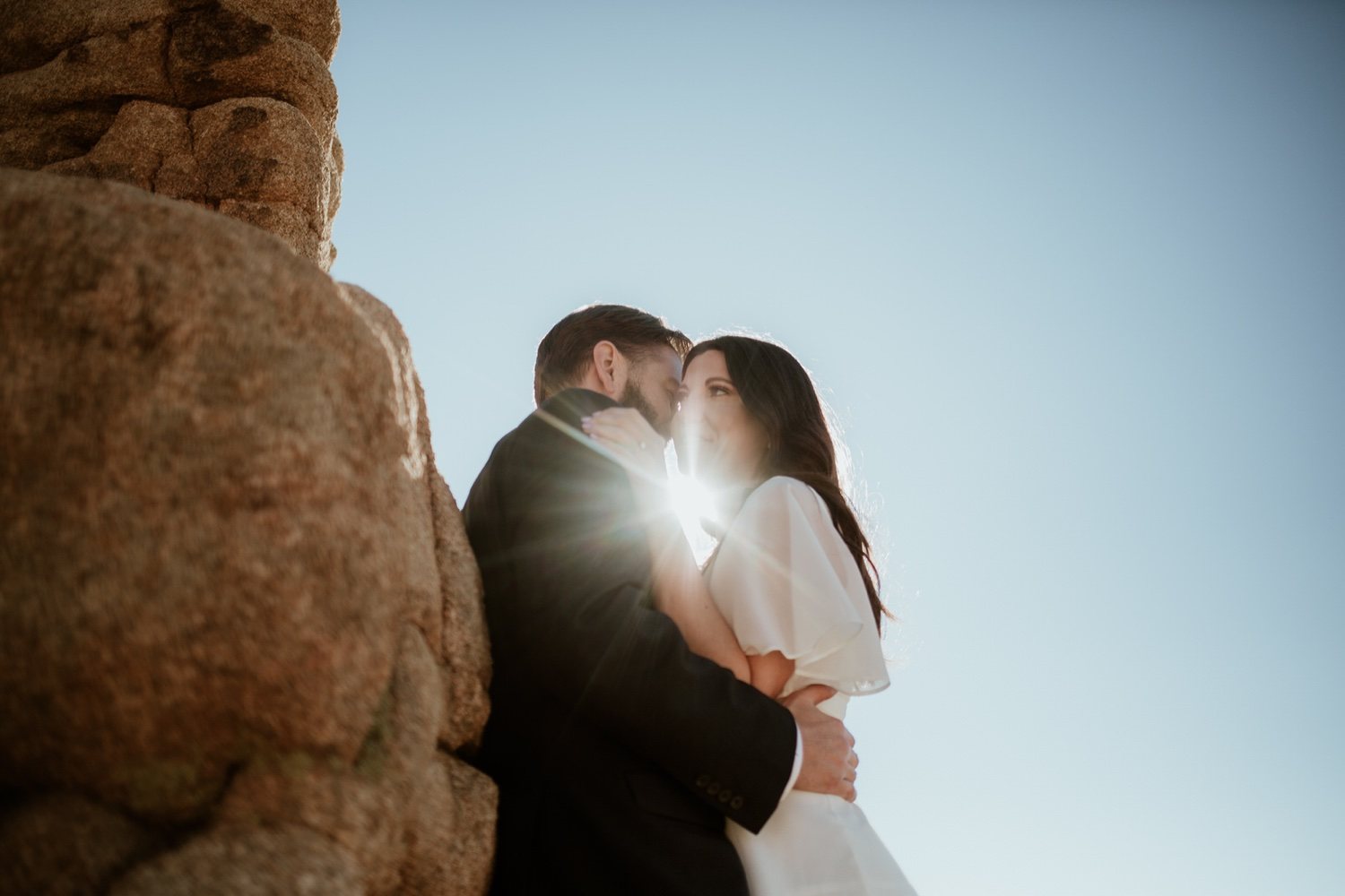 Sun flare through a kiss by the rocks